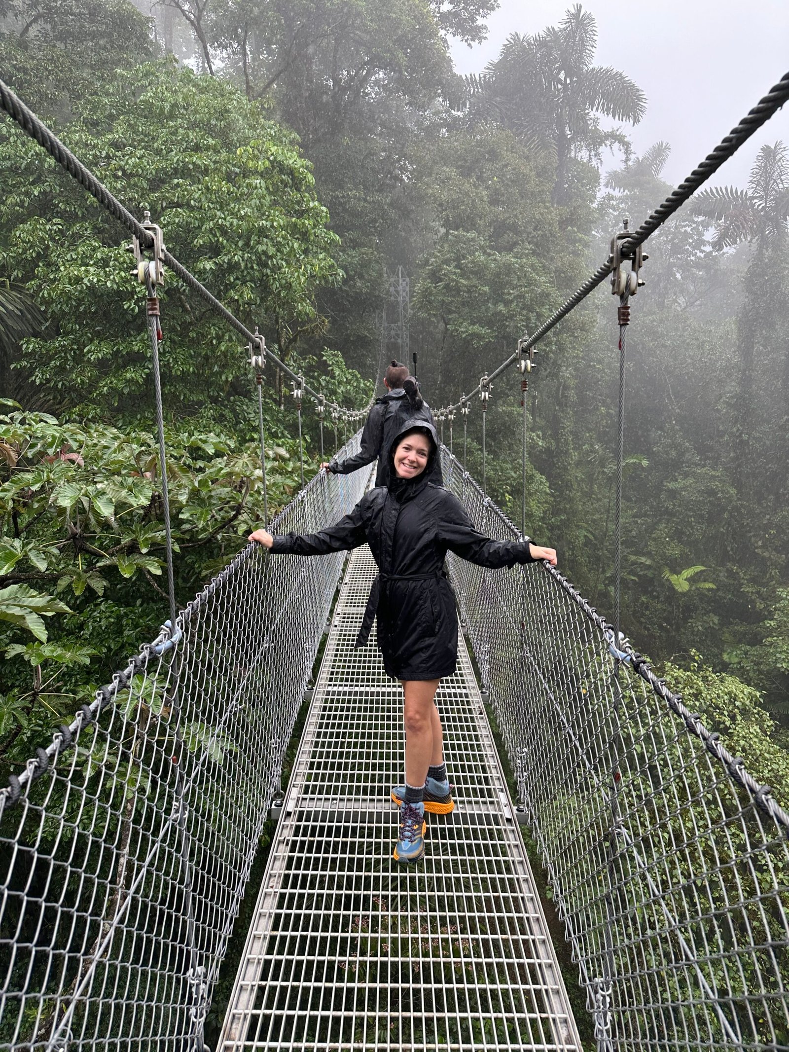 Traveler crossing a suspension bridge through the Costa Rica rainforest